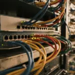 A detailed close-up of server rack network ports and intricate cabling bathed in warm, soft daylight